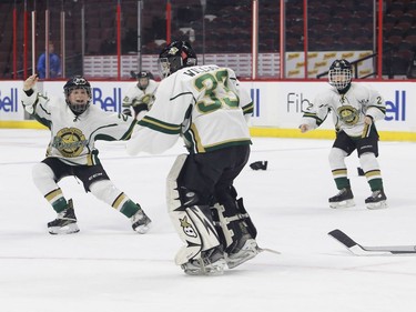 The Gloucester Rangers' Tanner Fennell, left, celebrates with goaltender Owen Willgos and Noah Jones, right, after defeating the Ajax Pickering Raiders in the Bell Capital Cup Minor Peewee AAA final.