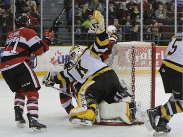 Frontenacs goalie Mario Peccia falls on the back of his net with a 67's player.