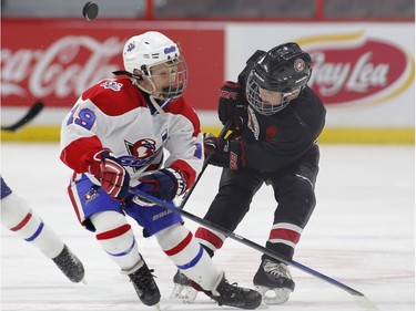 The St. Clair Shores Stars' Rory Savage, right, and the Long Island Gulls' Matt Grimes try to gain control of the puck in the Minor Atom AAA final.