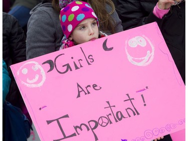 Seven-year-old Sara Poitras-George shows her bright pink sign saying Girls Are Important.