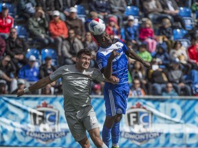 Tom Ameobi of FC Edmonton, gets a touch on the ball before Ramon Martin Del Campo of Puerto Rico FC.