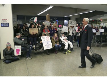 Travellers arriving to at the international gate of the Minneapolis-St. Paul International Airport are greeted by protesters.