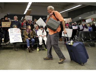 Travellers arriving to at the international gate of the Minneapolis-St. Paul International Airport are greeted by protesters.