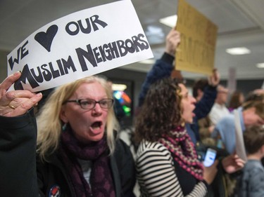 Protesters gather at the international arrivals area of the Washington Dulles International Airport on Saturday, Jan. 28, 2017, in Sterling, Va. U.S. President Donald Trump boasted Saturday that his "very strict" crackdown on Muslim immigration was working "very nicely," amid mounting resistance to the order that has been branded by many as blatantly discriminatory.