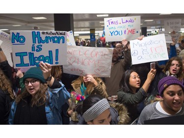 Protesters gather at the international arrivals area of the Washington Dulles International Airport.