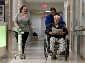 Volunteer Maggie Williams, right, wheels patient Gerald McCluskey down the new Queensway Carleton Hospital hallway of the ACE unit, which features things like a no-shine, no-slip floor, free from confusing designs.