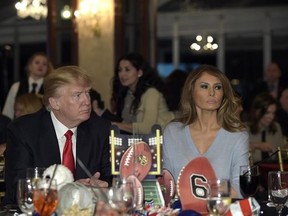 FILE - In this Feb. 5, 2017 file photo, President Donald Trump and first lady Melania Trump watch the Super Bowl at a party at Trump International Golf Club in West Palm Beach, Fla. First lady Melania Trump isn‚Äôt living in the White House and has said little about what she intends to do with her prominent position. But in new court documents, her lawyers argue that the ‚Äúmulti-year term‚Äù during which she ‚Äúis one of the most photographed women in the world‚Äù should mean millions of dollar