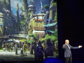 FILE - In this Saturday, Aug. 15, 2015, file photo, Bob Chapek, chairman of Walt Disney Parks and Resorts, speaks in front of concept art of the newly announced Star Wars Land at the D23 Expo in Anaheim, Calif. Disney CEO Bob Iger said Tuesday, Feb. 7, 2017, the company will open its Star Wars-themed lands at California‚Äôs Disneyland and Florida‚Äôs Walt Disney World in 2019. (Mindy Schauer/The Orange County Register via AP, File)