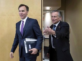 Minister of Finance Bill Morneau is greeted by Senator Larry Smith (right) as he appears at a National Finance Senate committee on Tuesday, June 7, 2016 in Ottawa. A Senate committee chaired by Smith warns that the Liberal government could end up wasting billions in new infrastructure money unless it develops a detailed strategy to dole out the cash in the coming years. THE CANADIAN PRESS/Justin Tang