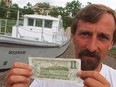 Paul Grorge, the curator of the Children's museum, with an old one dollar bill. The picture on the back of the bill is of a logging boat working on the Ottawa river below the parliament buildings. The actual boat the 'Missinaibi' is behind him and is now part of the museum. Picture taken in 1996.