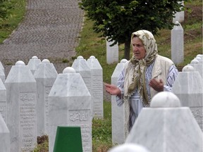 A Bosnian Muslim woman, survivor of the 1995 Srebrenica massacre, says a prayer for her lost relatives burried within the memorial cemetery, in Potocari, near Srebrenica, in June 2011.