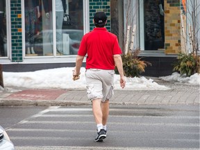 A pedestrian wearing only shorts and a golf shirt crosses Churchill St as the weather temperatures continue to be mild for the next few days.