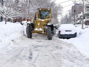 A snow grader navigates the narrow stretch of Third Avenue in Ottawa on Feb. 15, 2017 following a second snowstorm in less than a week.