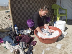 A Yazidi woman does her laundry at a camp for internal displaced persons, Wednesday, February 22, 2017 in Dohuk, Iraq. Canada has promised to accept hundreds of Yazidi refugees by the end of the year.