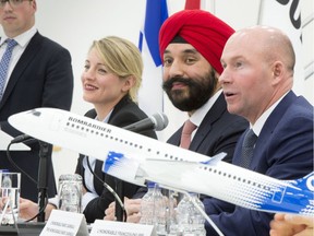 Bombardier President and CEO Alain Bellemare, right responds to a question as Heritage Minister Melanie Joly, left, and Innovation Minister Navdeep Bains look on Tuesday, February 7, 2017 in Montreal. The federal government says it will give Bombardier $372.5 million in repayable loans over four years to support the Global 7000 and CSeries aircraft projects.