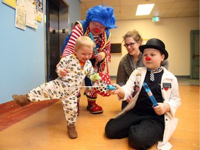 Anthony Farinon, 11, right, and Molly Penny the Clown have fun with CHEO patient Thomas McDermott and his mom Karin Selst-McDermott at CHEO, February 10, 2017.