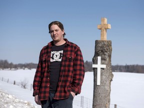 Blake Murray, who works for the City of Ottawa, stands near the tree he saved and cut a cross into with his chainsaw, Saturday, Feb. 18, 2017 in Ottawa.