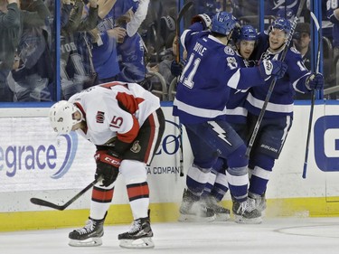 Tampa Bay Lightning center Brayden Point (21) celebrates with center Brian Boyle (11) and left wing Ondrej Palat (18), of the Czech Republic, after scoring against the Ottawa Senators during the third period of an NHL hockey game Thursday, Feb. 2, 2017, in Tampa, Fla. Skating back to the bench is center Zack Smith (15). The Senators won 5-2.