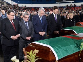 Right to left, Prime Minister Justin Trudeau, Quebec Premier Philippe Couillard, Quebec City Mayor Regis Labeaume and Montreal Mayor Denis Coderre pay their respects at the caskets of the victims of the Quebec City mosque shooting.