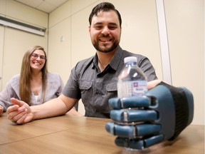 David Chasse, who had most of his hand ripped off in an accident in June, 2015, receives the first artificially-printed 3D hand at the Ottawa Hospital's General campus Thursday (Feb. 2, 2017). Joined by his girlfriend, Karine Turpin, the 33-year-old Renfrew security guard was ecstatic with the prototype - even able to pick up a bottle of water within seconds of the team fastening it to his wrist.  Julie Oliver/Postmedia