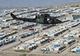 A Canadian Forces Griffon helicopter flies over a Internal Displaced persons camp near Erbil, Iraq, February 20, 2017. THE CANADIAN PRESS/Ryan Remiorz ORG XMIT: RYR112