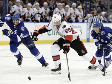 Ottawa Senators defenseman Erik Karlsson gets between Tampa Bay Lightning defenceman Jason Garrison (5) and left wing Ondrej Palat (18), during the third period of an NHL hockey game Thursday, Feb. 2, 2017, in Tampa, Fla. The Senators won 5-2.