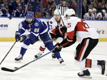 Tampa Bay Lightning right wing Nikita Kucherov (86), of Russia, tries to stick-handle around Ottawa Senators center Kyle Turris (7) and defenseman Erik Karlsson (65), of Sweden, during the second period of an NHL hockey game Thursday, Feb. 2, 2017, in Tampa, Fla.