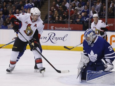 The Leafs' Frederik Andersen makes a save on Dion Phaneuf.