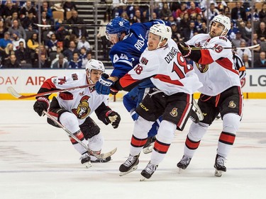 Toronto Maple Leafs defenceman Morgan Rielly bodychecks the Ottawa Senators' Ryan Dzingel.