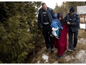 HEMMINGFORD, QUEBEC - FEBRUARY 23: A mother and child from Turkey are escorted by Royal Canadian Mounted Police after they crossed the U.S.-Canada border into Canada, February 23, 2017 in Hemmingford, Quebec. In the past month, hundreds of people have crossed Quebec land border crossings in attempts to seek asylum and claim refugee status in Canada.
