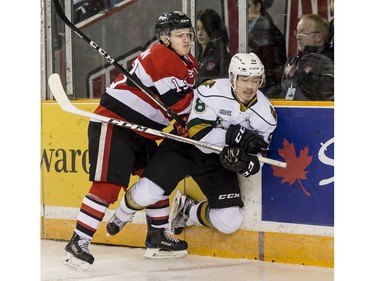 The Ottawa 67's Artur Tyanulin checks the London Knights' Mitchell Vande Sompel into the boards.