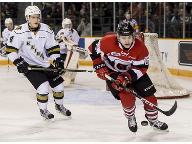 The 67's Ben Evans controls a loose puck as he is pursued by the Knights' Olli Juolevi.