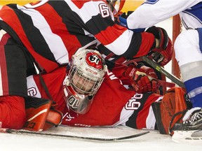 Players pile on 67’s goalie Olivier Lafreniere during Sunday's game against the Sudbury Wolves.