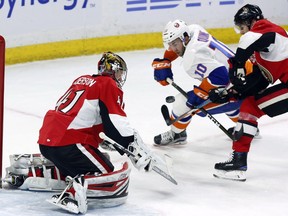 Ottawa Senators goalie Craig Anderson makes a save in front of New York Islanders centre Alan Quine as Senators defenceman Erik Karlsson defends during the second period at the Canadian Tire Centre on Saturday, Feb. 11, 2017.