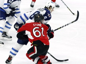 Ottawa Senators' Mark Stone (61) is hit hard by Winnipeg Jets' Jacob Trouba (8) during third period NHL hockey action in Ottawa on, Sunday February 19, 2017.