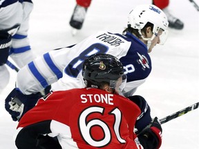 The Ottawa Senators' Mark Stone is hit by the Winnipeg Jets' Jacob Trouba (8) during the third period on Sunday, Feb. 19, 2017. The NHL has suspended Trouba for two games for an illegal check to the head.