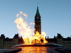 The Centre Block of the Parliament Buildings is shown through the Centennial Flame on Parliament Hill in Ottawa on Sunday, January 25, 2015.