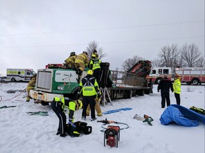 Firefighters cut into a truck to extricate a patient at a crash at Eagleson and Fallowfield.