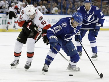 Tampa Bay Lightning center Brayden Point (21) battles with Ottawa Senators left wing Tom Pyatt (10) for a loose puck during the first period of an NHL hockey game Thursday, Feb. 2, 2017, in Tampa, Fla.