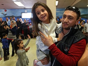 Yasser Jakl dances with daughter Estervan, 4, during a celebration marking the first anniversary of the arrival of Syrian refugees, at the Freight House Community Centre on Ross Avenue in Winnipeg, on Sat., Jan. 7, 2017.