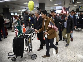 WASHINGTON, DC - FEBRUARY 06:  Ammar Aquel Mohammed Aziz (C), escorted by members of his family already living in the United States, arrives from Yemen at Dulles International airport on February 6, 2017 in Washington, DC. Aziz and his brother Tareq were prohibited from entering the U.S. a week ago due to tightened immigration policies established by the Trump administration, but were able to travel freely this week following a court injunction halting the implementation of the immigration policy. Some of Canada's universities are exploring how to help those affected.