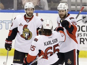 The Senators' Zack Smith (15), Tom Pyatt (10) and Erik Karlsson celebrate after a goal by Smith.