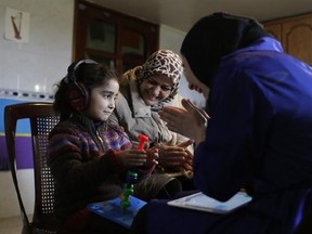 In this Sunday, March 12, 2017 photo, Syrian refugees Aya al-Souqi, left, smiles as receiving her first hearing test by Zaineb Abdulla, right, the Vice President of &ampquot;Deaf Planet Soul&ampquot; Chicago hearing charity at Joub Jannine village in the Bekaa valley, east Lebanon, Sunday, Sunday, March 12, 2017. The proudly named &ampquot;Deaf Planet Soul&ampquot; Chicago hearing charity is bringing smiles to hard of hearing Syrian children and their parents in Lebanon on a two-week long mission to treat hearing loss. It is,