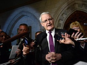 Transport Minister Marc Garneau speaks to reporters in the foyer of the House of Commons on Parliament Hill in Ottawa on Tuesday, March 21, 2017. Canada&#039;s transport minister says the federal government is taking a close look at the circumstances behind efforts in the United States and the U.K. to ban certain electronic devices from carry-on baggage.But Marc Garneau is stopping short of saying whether Canada will follow the lead of the two countries in banning the devices from flights originating