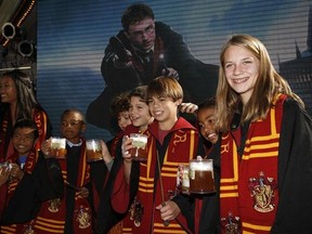 FILE - In this Dec. 6, 2011. file photo, fans dress up as students from Hogwarts School of Witchcraft and Wizardry make a butterbeer toast as Universal Parks & Resorts announces the Harry Potter attraction is coming to Universal Studios Hollywood in Universal City, Calif. Pennsylvania&#039;s Yuengling&#039;s Ice Cream launched a butterbeer flavored ice cream on March 20, 2017. (AP Photo/Jason Redmond, File)