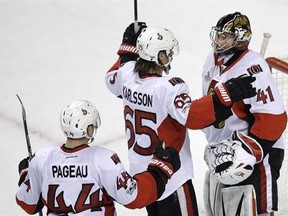 Ottawa Senators goalie Craig Anderson (41) is congratulated by Erik Karlsson (65) and Jean-Gabriel Pageau (44) after defeating the Boston Bruins 3-2 during an NHL hockey game in Boston, Tuesday, March 21, 2017. (AP Photo/Charles Krupa)