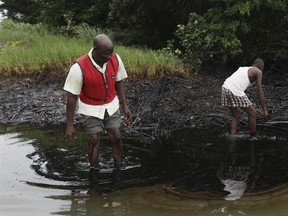 FILE- In this Sunday June. 20, 2010 file photo, men walk in an oil slick covering a creek near Bodo City in the oil-rich Niger Delta region of Nigeria. Royal Dutch Shell&#039;s Nigeria subsidiary &ampquot;fiercely opposed&ampquot; environmental testing and is concealing data showing thousands of Nigerians are exposed to health hazards from a stalled cleanup of the worst oil spills in the West African nation&#039;s history, according to a German geologist contracted by the Dutch-British multinational.(AP Photo/Sunday Alam