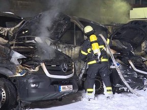 In this March 27, 2017 photo, a firefighter tries to extinguish burning police vehicles in Hamburg, Germany. Anti-G20 protesters have claimed responsibility for torching a half dozen police transport vehicles at a lot in Hamburg. In a message on a leftist forum online, an anonymous poster wrote the attack was meant to ‚Äúheat up the days before the summit,‚Äù the dpa news agency reported Tuesday March 28, 2017. (Mucahid Guler/dpa via AP)
