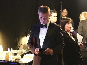 FILE - In this Feb. 26, 2017, file photo, PwC accountant Brian Cullinan, center, holds red envelopes under his arm while using his cell phone backstage at the Oscars at the Dolby Theatre in Los Angeles. PwC accountants won‚Äôt be allowed to have their cellphones backstage during future Oscar telecasts. Film academy president Cheryl Boone Isaacs sent an email to academy members Wednesday, March 29, 2017, detailing the new protocols established for announcing Oscar winners after the best-picture f