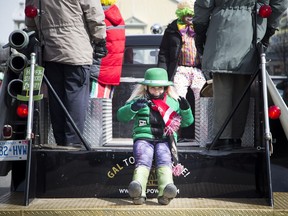 A bundled up parader waves to the crowd at Saturday's chilly St. Patrick's Day Parade on March 11, 2017. Ashley Fraser, Postmedia